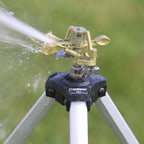 Melnor Metal Pulsating Sprinkler with Tripod watering green grass