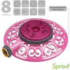 This is an image of a pink, circular, decorative garden hose sprinkler with eight patterns indicated above it and a claim of a metal base resisting tipping.