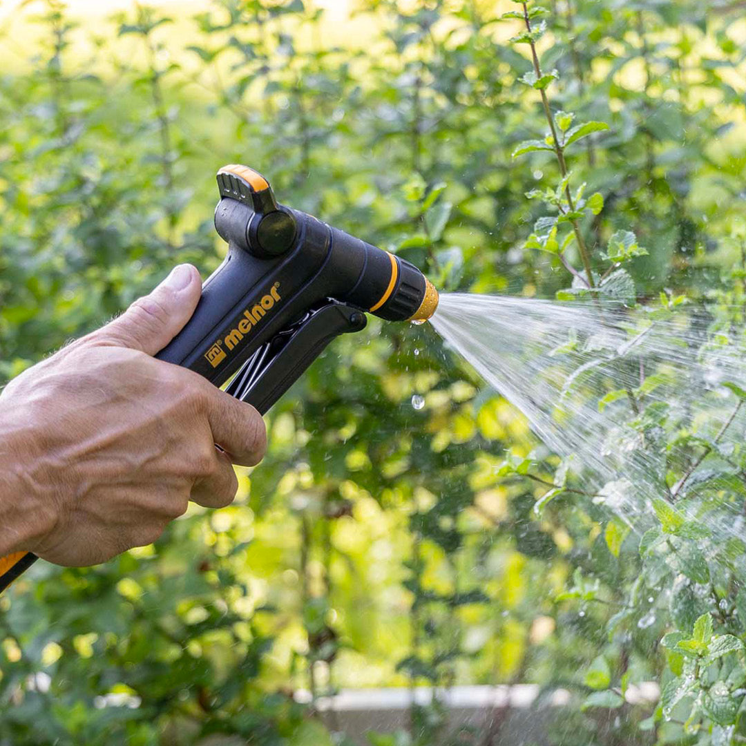 Melnor XT300 Front Trigger Metal Adjustable Nozzle with Flow Control using the mist spray setting to water green plants.
