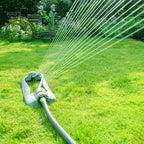 Melnor XT45360M garden sprinkler watering grass with a garden and flowers in the background.