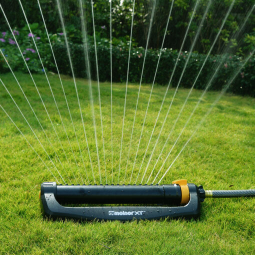 Melnor XT 4,000 Sq. Ft. Oscillating Sprinkler gently spraying water over green lawn