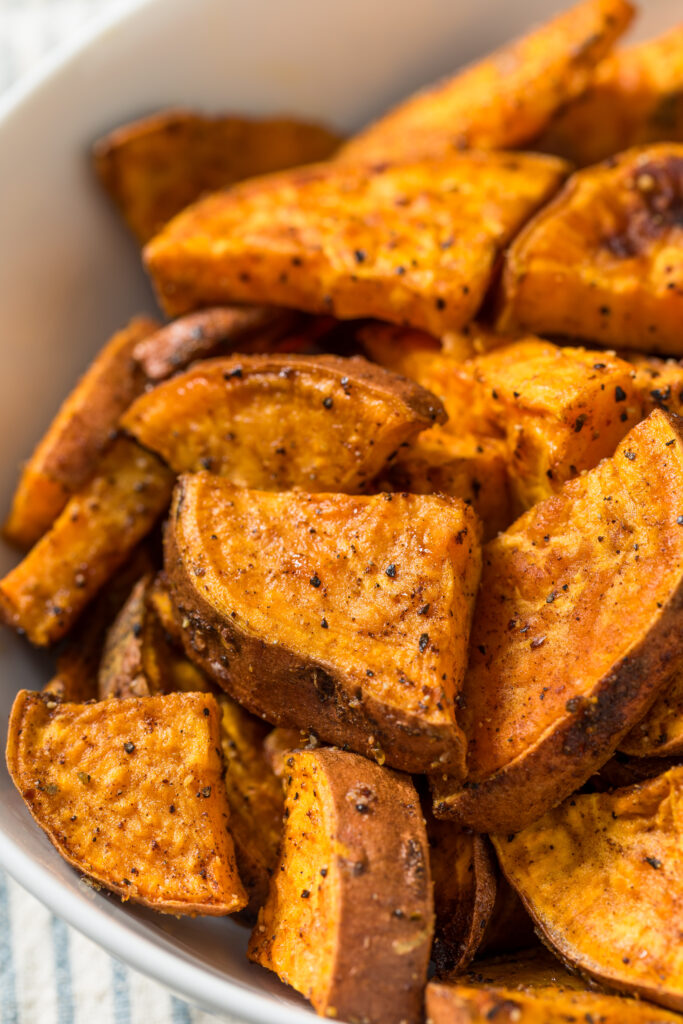 Bowl of roasted sweet potato wedges seasoned and ready to serve.